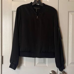 Black bomber with side zipper details and faux pockets
